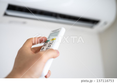 エアコンのリモコンを操作する手 エアコンのリモコンを操作する手 137118753