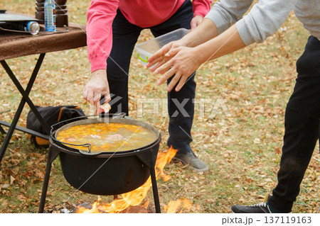 Fish soup cooking over fire in metal cauldron Fish soup cooking over fire in metal cauldron 137119163