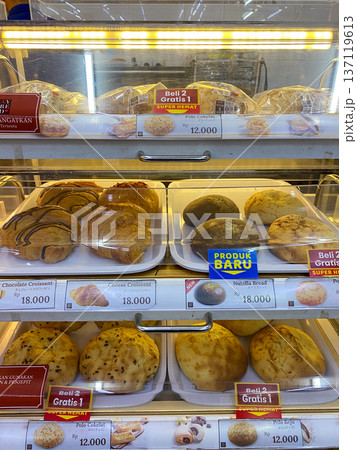 Jakarta, Indonesia - February 08 2026: Various selections of sweet breads like chocolate, cheese, and Say Bread croissants neatly arranged inside a bakery display case. Jakarta, Indonesia - February 08 2026: Various selections of sweet breads like chocolate, cheese, and Say Bread croissants neatly arranged inside a bakery display case. 137119613