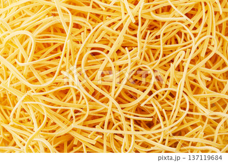 Dry egg pasta noodles creating yellow texture background 137119684