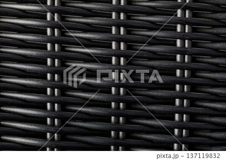 Dark synthetic wicker weaving creating patterned background texture 137119832