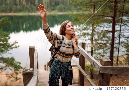 Attractive young woman enjoying fresh air on the lake. Travel, Hiking, nature 137120256