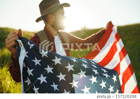 4th of July. American Flag.Patriotic holiday. Traveler with the flag of America. Beautiful sunset light. American style. 4th of July. American Flag.Patriotic holiday. Traveler with the flag of America. Beautiful sunset light. American style. 137120288