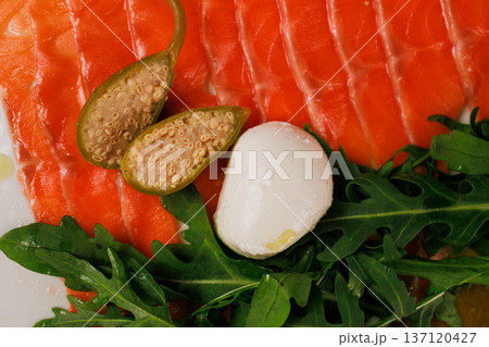 A plate with sliced red fish, bread and greens A plate with sliced red fish, bread and greens 137120427