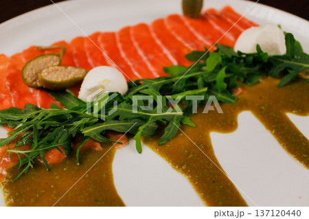 A plate with sliced red fish, bread and greens A plate with sliced red fish, bread and greens 137120440