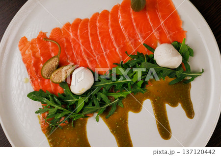 A plate with sliced red fish, bread and greens A plate with sliced red fish, bread and greens 137120442