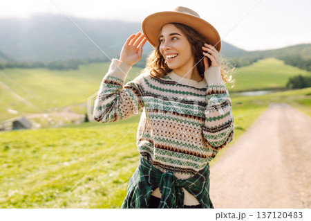 Happy female traveler exploring area in green valley with mountains in background. Concept of nature Happy female traveler exploring area in green valley with mountains in background. Concept of nature 137120483