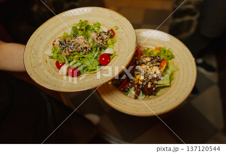 Delicious dishes on plates in the waiter's hand Delicious dishes on plates in the waiter's hand 137120544