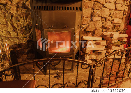 A burning iron fireplace in a cozy cafe A burning iron fireplace in a cozy cafe 137120564