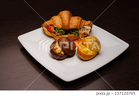 Croissant with salmon and stuffed buns on a plate 137120705