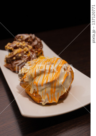 Cinnabon on a white plate and on a wooden table Cinnabon on a white plate and on a wooden table 137120771