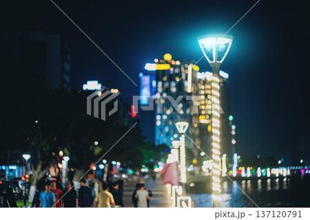 Modern led street lights along promenade alley in night city with reflections, Contemporary illuminated lamps on riverside walkway, glowing urban skyline Modern led street lights along promenade alley in night city with reflections, Contemporary illuminated lamps on riverside walkway, glowing urban skyline 137120791
