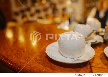 The sugar bowl stands on a wooden table 137120846