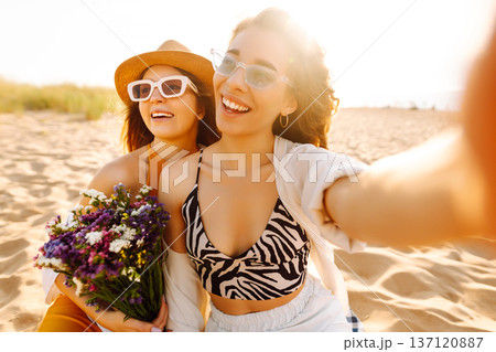 Two pretty friends women making selfie on beach, light and bright summer colors. Friends together Two pretty friends women making selfie on beach, light and bright summer colors. Friends together 137120887