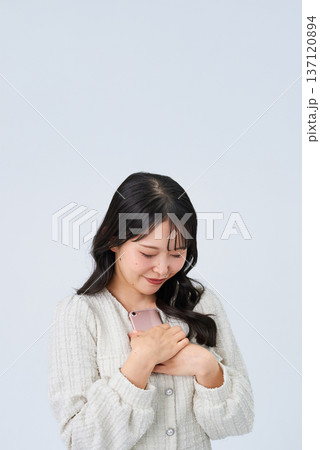 スマートフォンを持って笑顔の若い女性 137120894