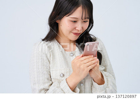 スマートフォンを持って笑顔の若い女性 スマートフォンを持って笑顔の若い女性 137120897