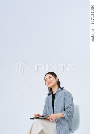 カジュアルな服装でタブレットPCを使う若い女性 137121380
