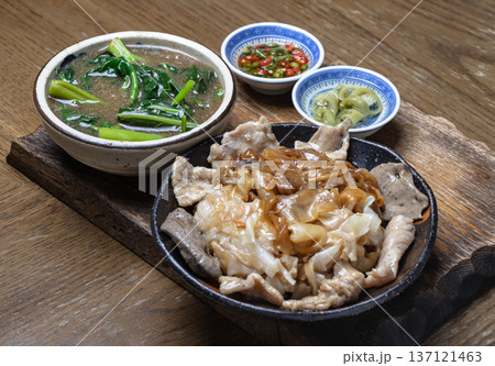 Wide rice noodles served with marinated pork and Chinese kale in a rich, thick gravy sauce. Wide rice noodles served with marinated pork and Chinese kale in a rich, thick gravy sauce. 137121463