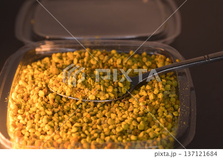 Close-up of natural bee pollen granules in vibrant yellow and orange tones, showcasing their organic texture. Close-up of natural bee pollen granules in vibrant yellow and orange tones, showcasing their organic texture. 137121684