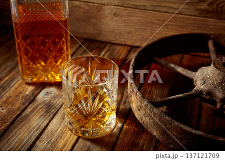 Elegant whiskey glass and decanter on a old wooden table. 137121709