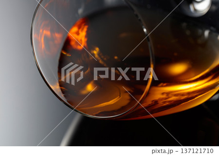 Glass of brandy on a black reflective background. Glass of brandy on a black reflective background. 137121710