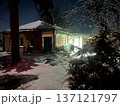 A cute old house with glowing windows on a winter evening.  137121797