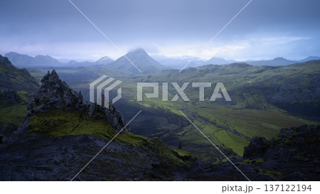 Volcanic landscape with black sharp rocks and mountains with cloudy sky above, Highlands, Iceland Volcanic landscape with black sharp rocks and mountains with cloudy sky above, Highlands, Iceland 137122194