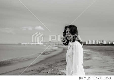 Woman Laughing Joyfully on a Sandy Beach Woman Laughing Joyfully on a Sandy Beach 137122593