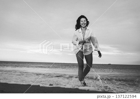 Woman Laughing While Walking Along Beach in Shirt 137122594