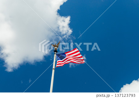 A large American flag is flying high in the sky A large American flag is flying high in the sky 137123793