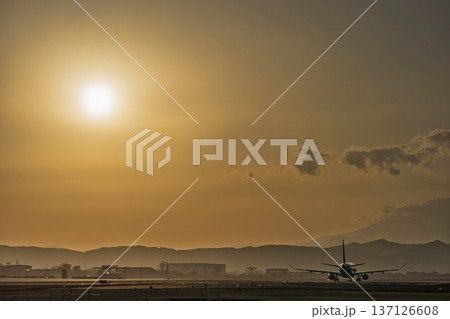 夕暮れの仙台空港　夕日と離陸中の飛行機　宮城県名取市 137126608