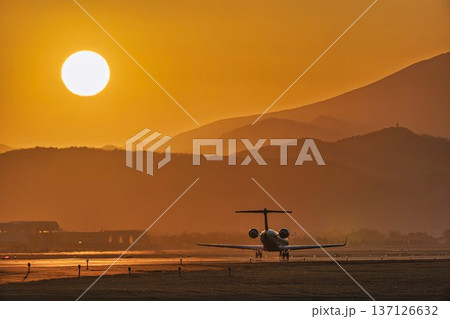 夕暮れの仙台空港　夕日と離陸中の飛行機　宮城県名取市 137126632