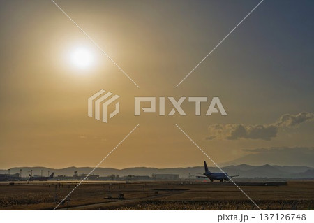 夕暮れの仙台空港 夕日と離陸中の飛行機 宮城県名取市 夕暮れの仙台空港 夕日と離陸中の飛行機 宮城県名取市 137126748