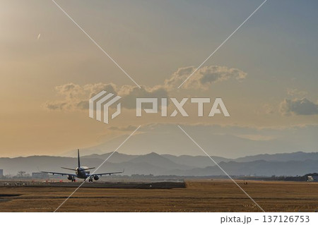 夕暮れの仙台空港　夕日と離陸中の飛行機　宮城県名取市 137126753