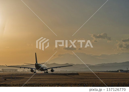 夕暮れの仙台空港　夕日と離陸中の飛行機　宮城県名取市 137126770