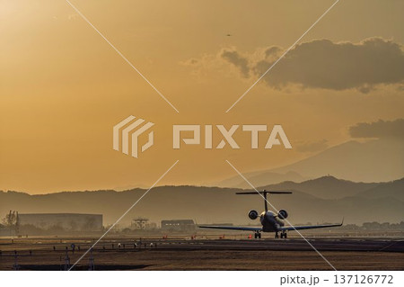 夕暮れの仙台空港　夕日と離陸中の飛行機　宮城県名取市 137126772
