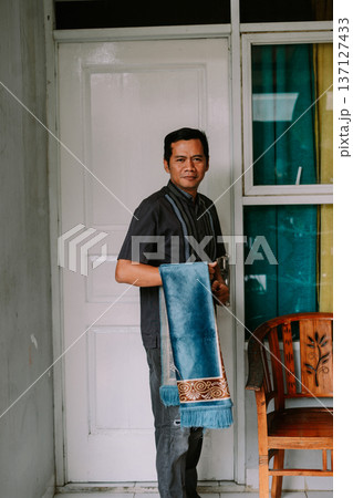 Devout Muslim Man Holding Traditional Blue Prayer Mat Devout Muslim Man Holding Traditional Blue Prayer Mat 137127433