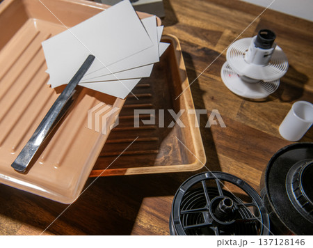 darkroom. Equipment for analog photography, developing tray, photographic paper, tongs in the tray. darkroom. Equipment for analog photography, developing tray, photographic paper, tongs in the tray. 137128146