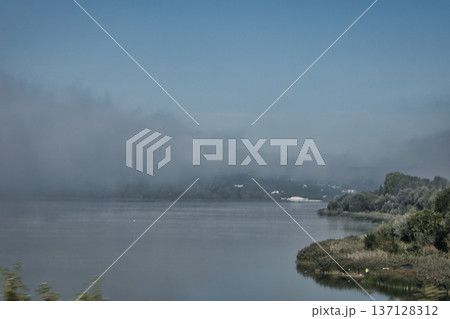 Foggy Lake Landscape with Distant Shoreline and Calm Water Foggy Lake Landscape with Distant Shoreline and Calm Water 137128312