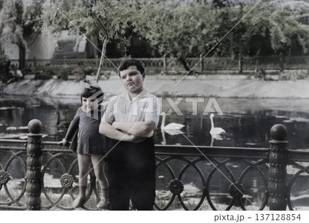 Vintage portrait of little sister and older brother walking in the park. Retro photo from 1972. 137128854