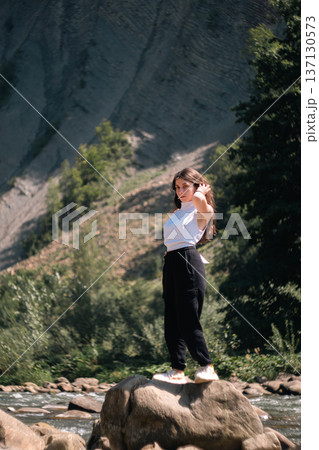 Young Woman Standing on Rock by Mountain River in Summer Nature Young Woman Standing on Rock by Mountain River in Summer Nature 137130573