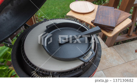 Ceramic grill with iron pan and wooden boards. 137130682