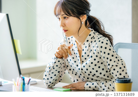 オフィスでパソコンを操作する若い女性 オフィスでパソコンを操作する若い女性 137131689