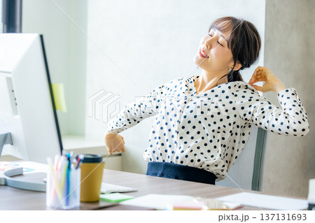 オフィスで伸びをする若い女性 137131693