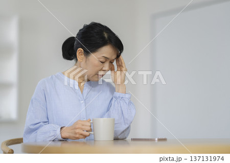 頭を抱える50代後半の女性 137131974