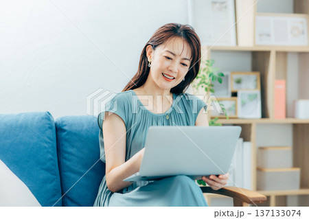 リビングでパソコンを見るミドル女性 137133074