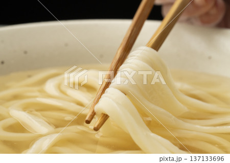 冷たいうどんを箸で持ち上げる 冷たいうどんを箸で持ち上げる 137133696