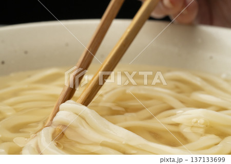 冷たいうどんを箸で持ち上げる 冷たいうどんを箸で持ち上げる 137133699