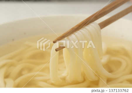 湯気の立った温かいうどんを箸で持ち上げる 湯気の立った温かいうどんを箸で持ち上げる 137133762