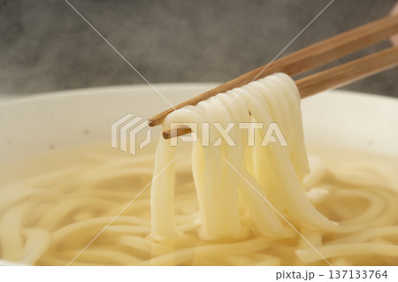 湯気の立った温かいうどんを箸で持ち上げる 137133764